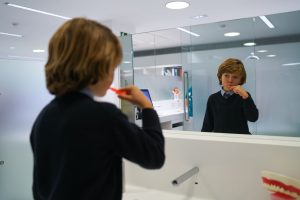 paciente infantil lavándose los dientes con brackets para combatir la halitosis