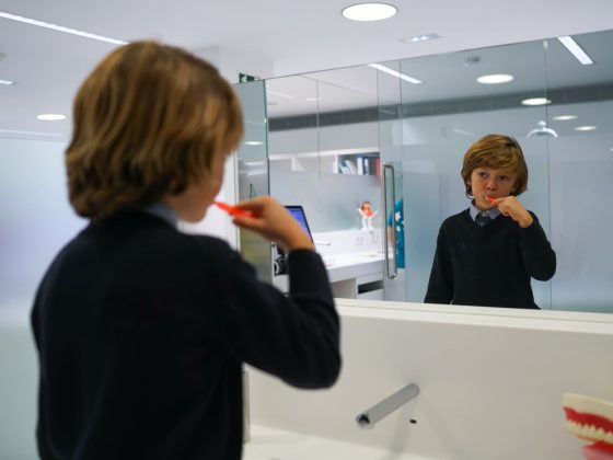 paciente infantil lavándose los dientes con brackets para combatir la halitosis